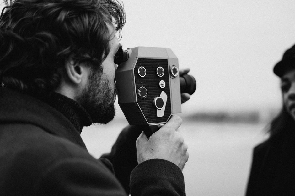A professional wedding videographer capturing a bride and groom during their ceremony.